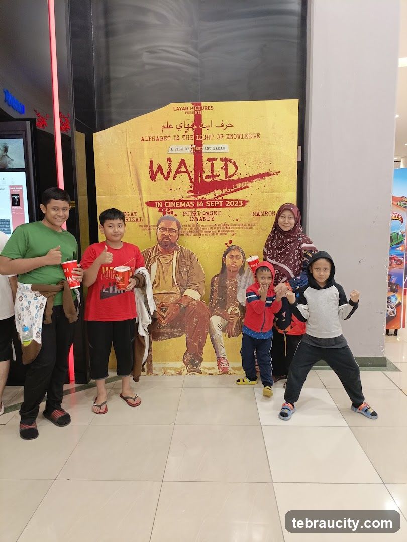 Family Poses in Front of Movie Poster
