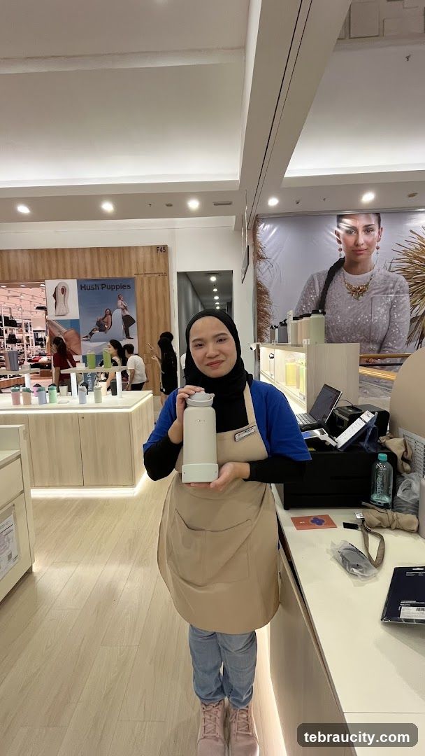 Store Employee Holding a Water Bottle
