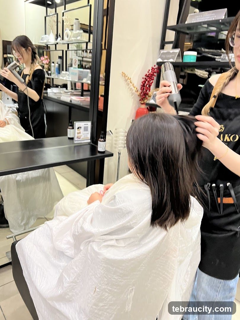 Hairdresser drying client's hair