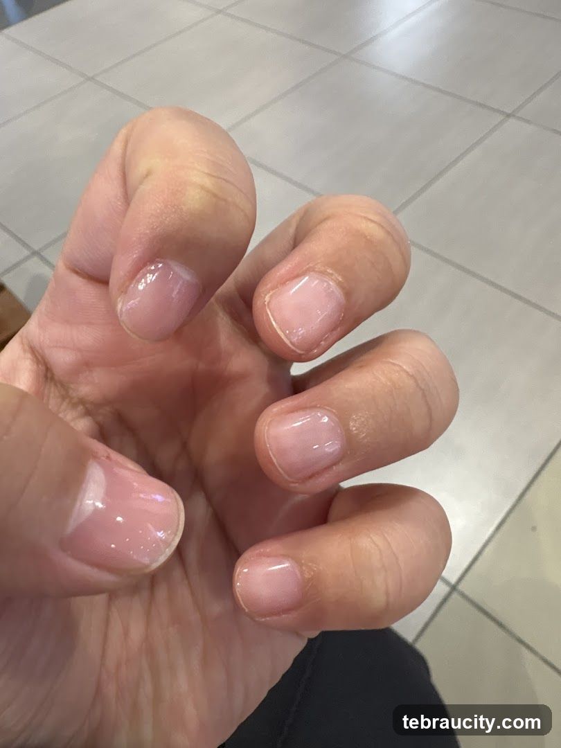 Close-up of a hand with light pink gel nails