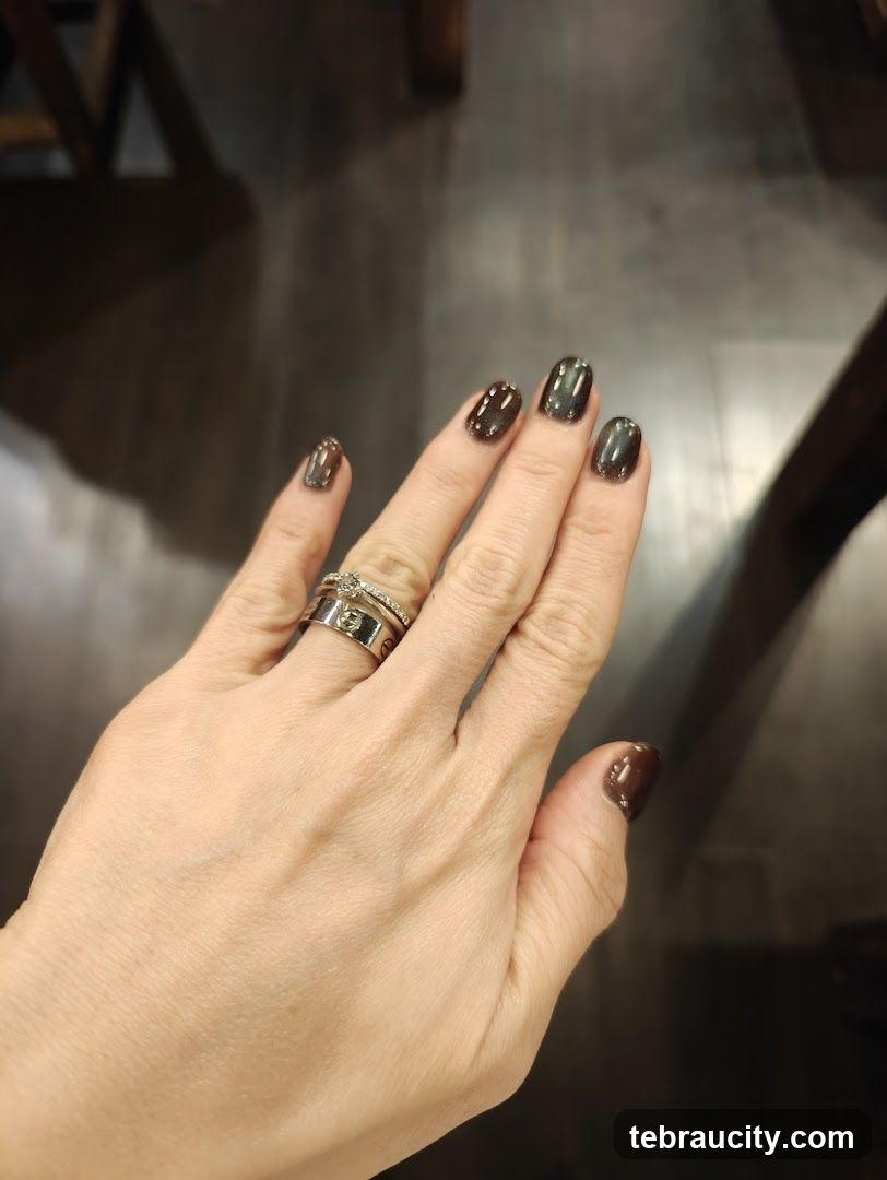 Woman's Hand with Dark Nail Polish and Rings