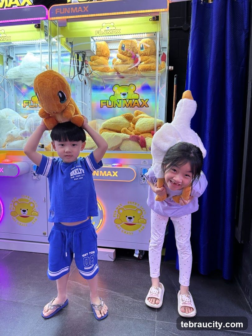 Children with stuffed toys in front of claw machines