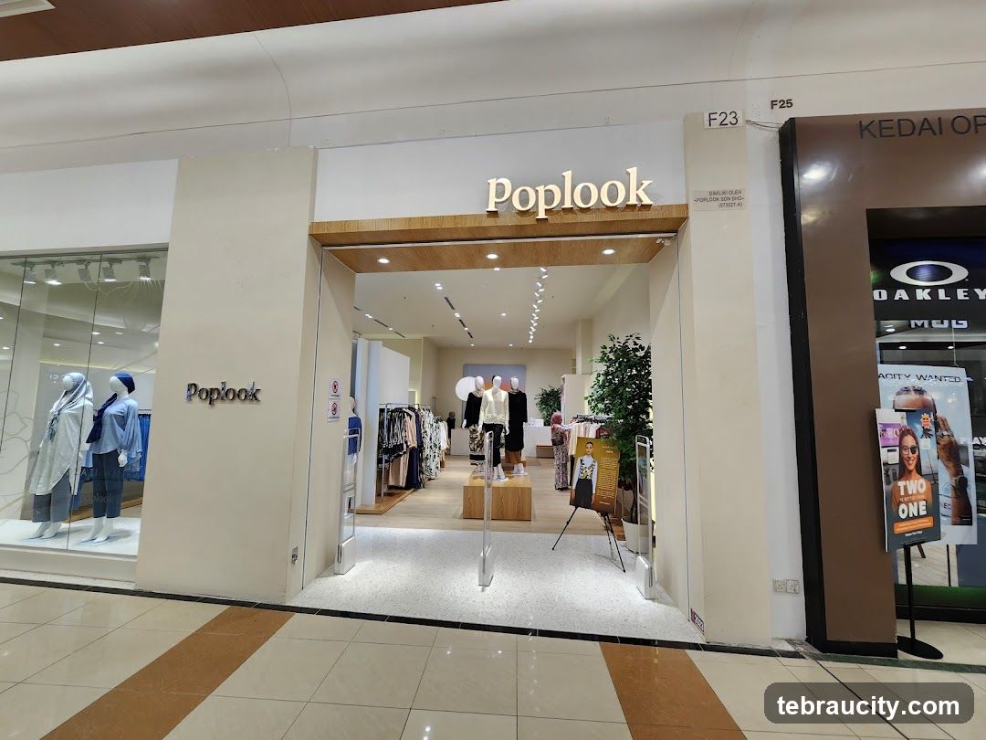 The exterior of a Poplook clothing store. The entrance is open, revealing mannequins dressed in clothing and racks of apparel inside. A sign with the Poplook logo is visible on the left side of the entrance. To the right of the Poplook store is another store with an Oakley logo.