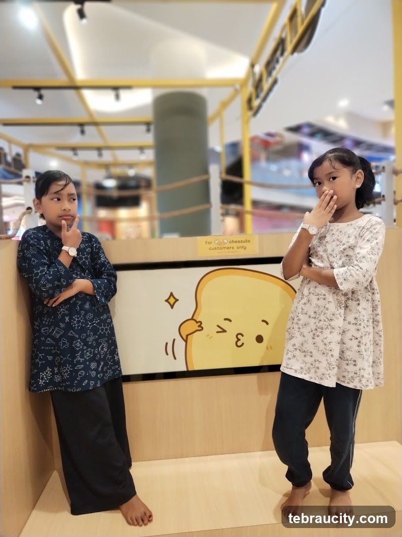 Two girls posing in front of a cartoon bread character