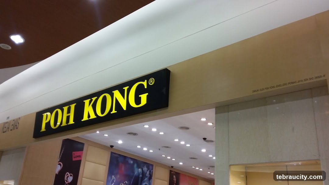 A sign for Poh Kong Jewellers is visible above the entrance to the store. The sign is black with yellow lettering. Below the sign, the store interior is visible, with displays of jewelry and promotional posters.
