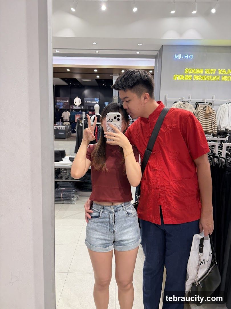 Couple taking a mirror selfie in a clothing store