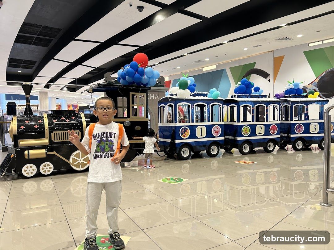 Boy Posing in Front of a Toy Train Ride