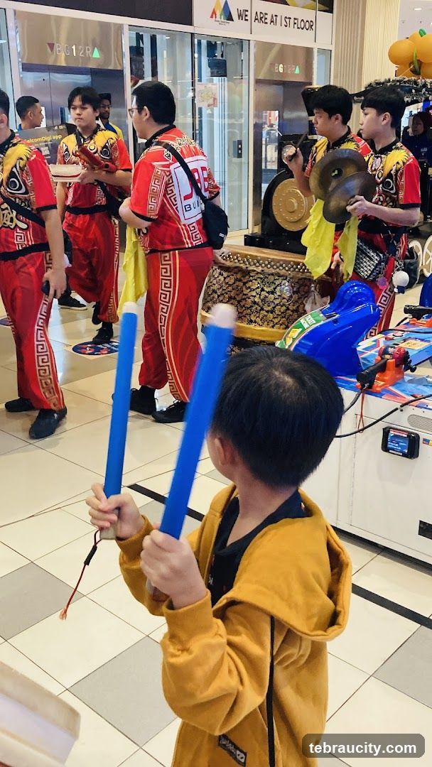 Lion Dance Performers and Child with Drumsticks