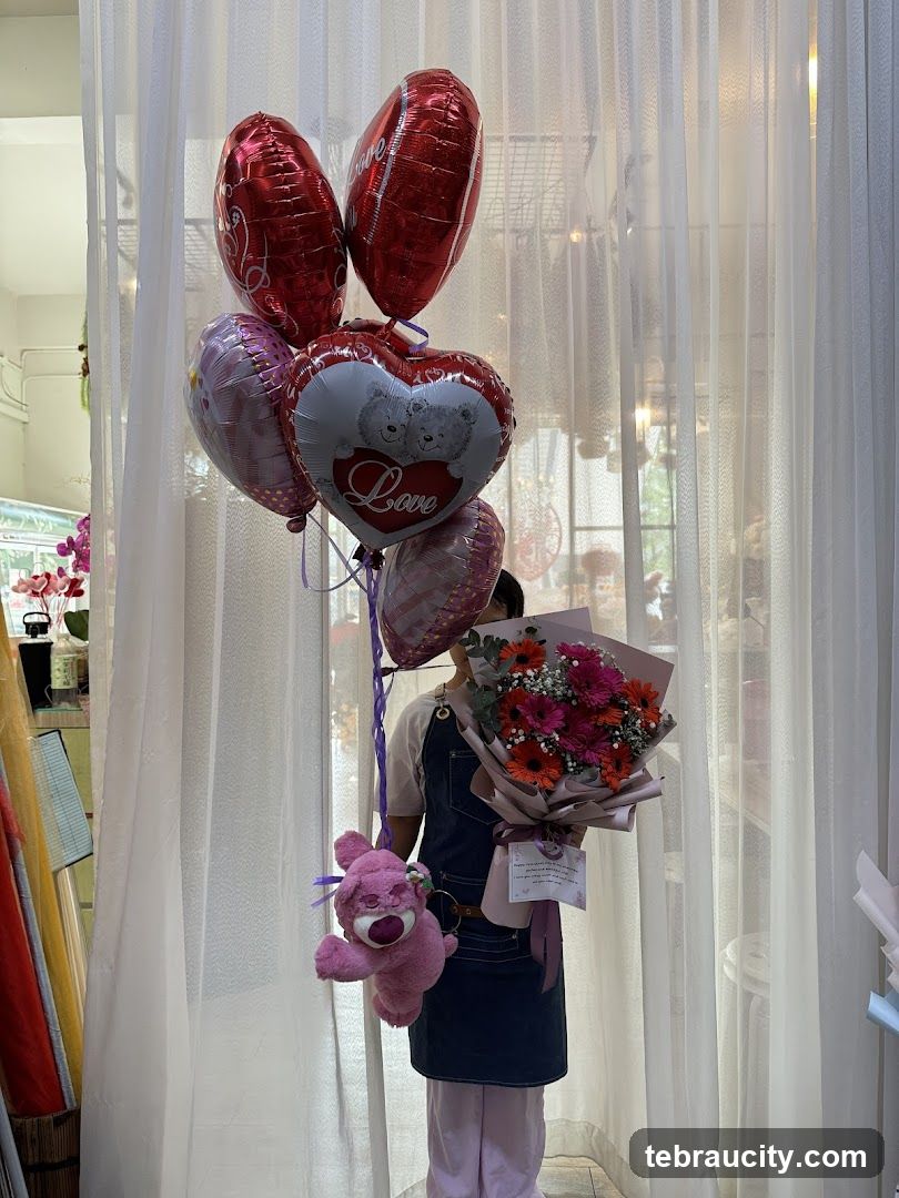 Person holding balloons and a bouquet