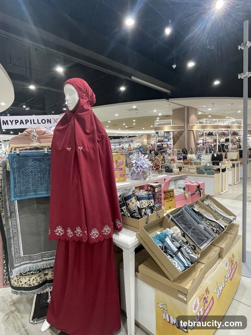 Mannequin in prayer dress with displayed prayer mats and accessories