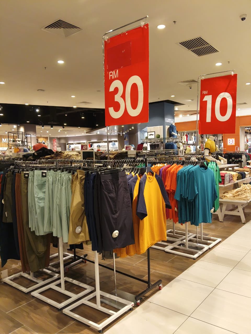 T-shirts and casual wear on racks priced at RM10 and RM30 during clearance sale