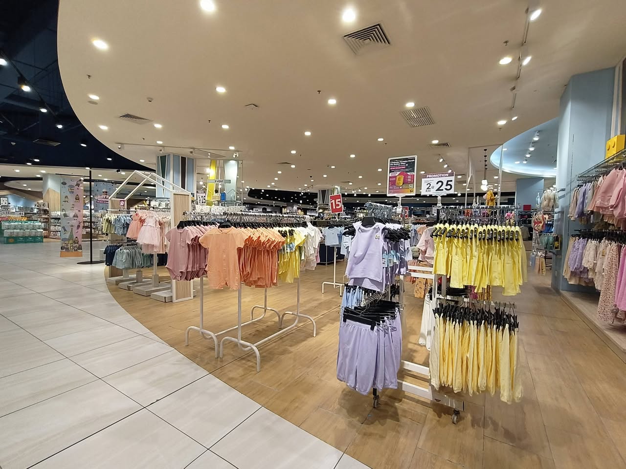 Pastel-coloured baby clothing on racks at the fair