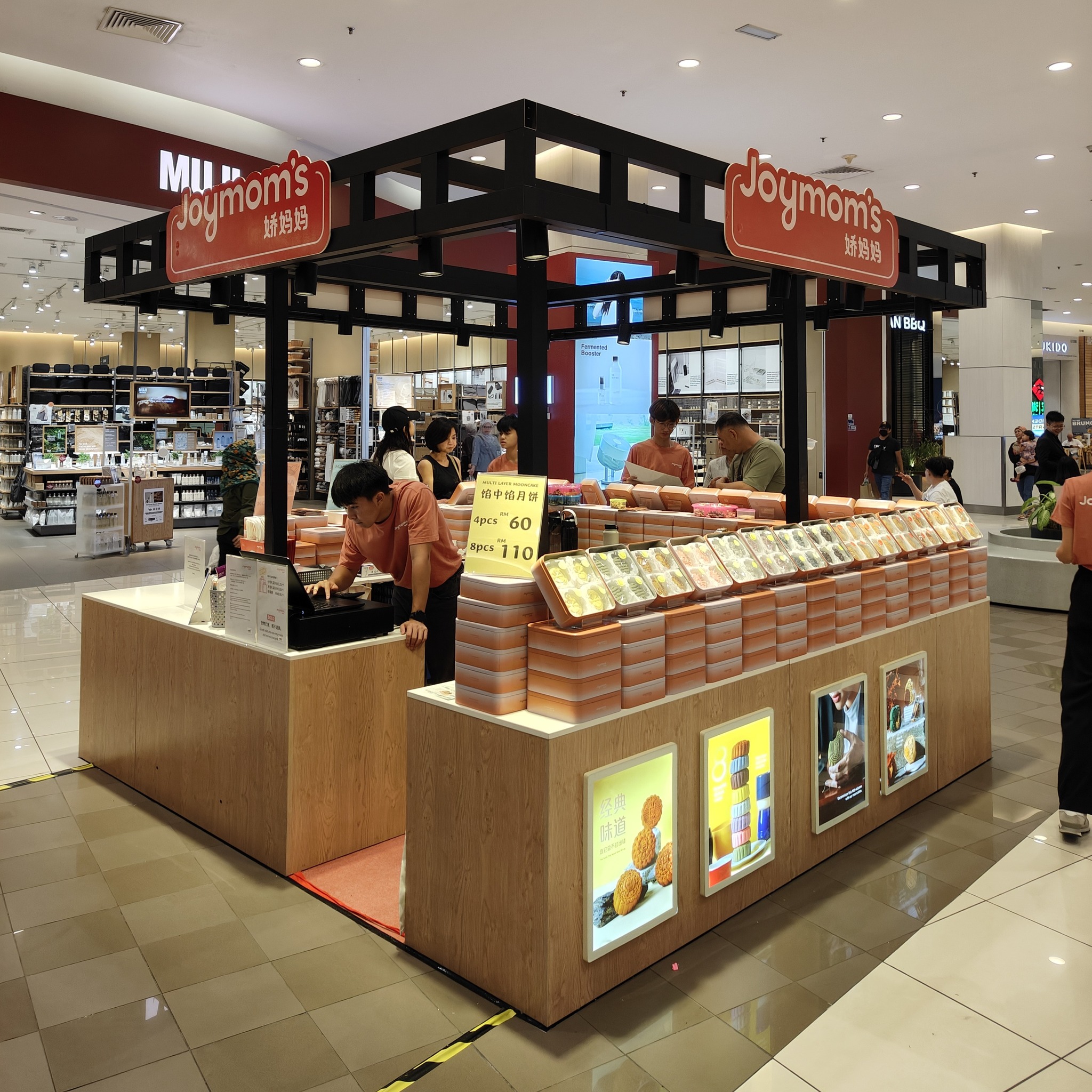 A bustling Jiao Mama mooncake booth with many visitors trying samples.