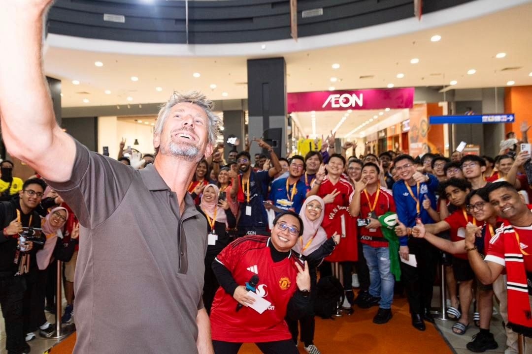 A large crowd of fans gathers excitedly at an AEON MALL.