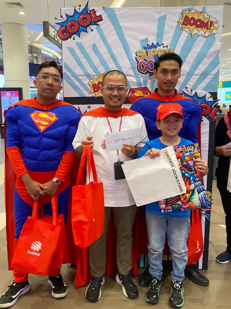 A group of young artists proudly displaying their finished Superman artworks.
