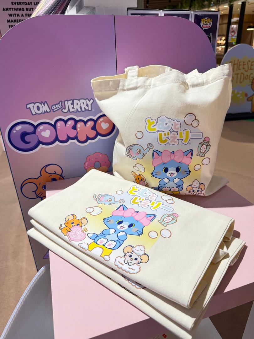 An expansive shot of the lively Tom & Jerry Gokko event space, filled with excited attendees and vibrant displays.