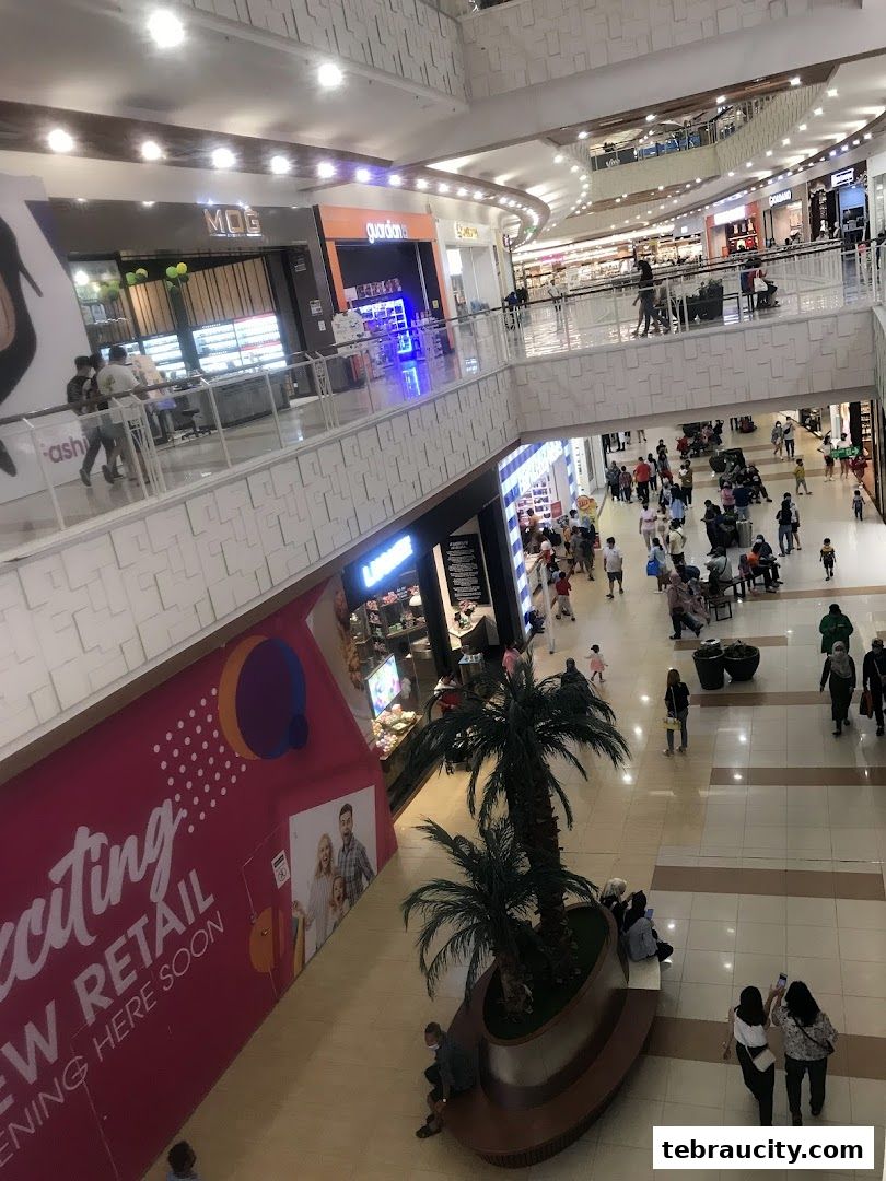Interior view of a busy shopping mall with multiple levels and shops.