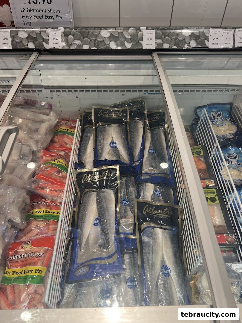 Frozen seafood products, including filament sticks and fish fillets, displayed in a refrigerated aisle.
