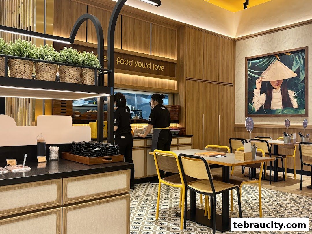 Interior of a Vietnamese restaurant with staff preparing food and dining tables.