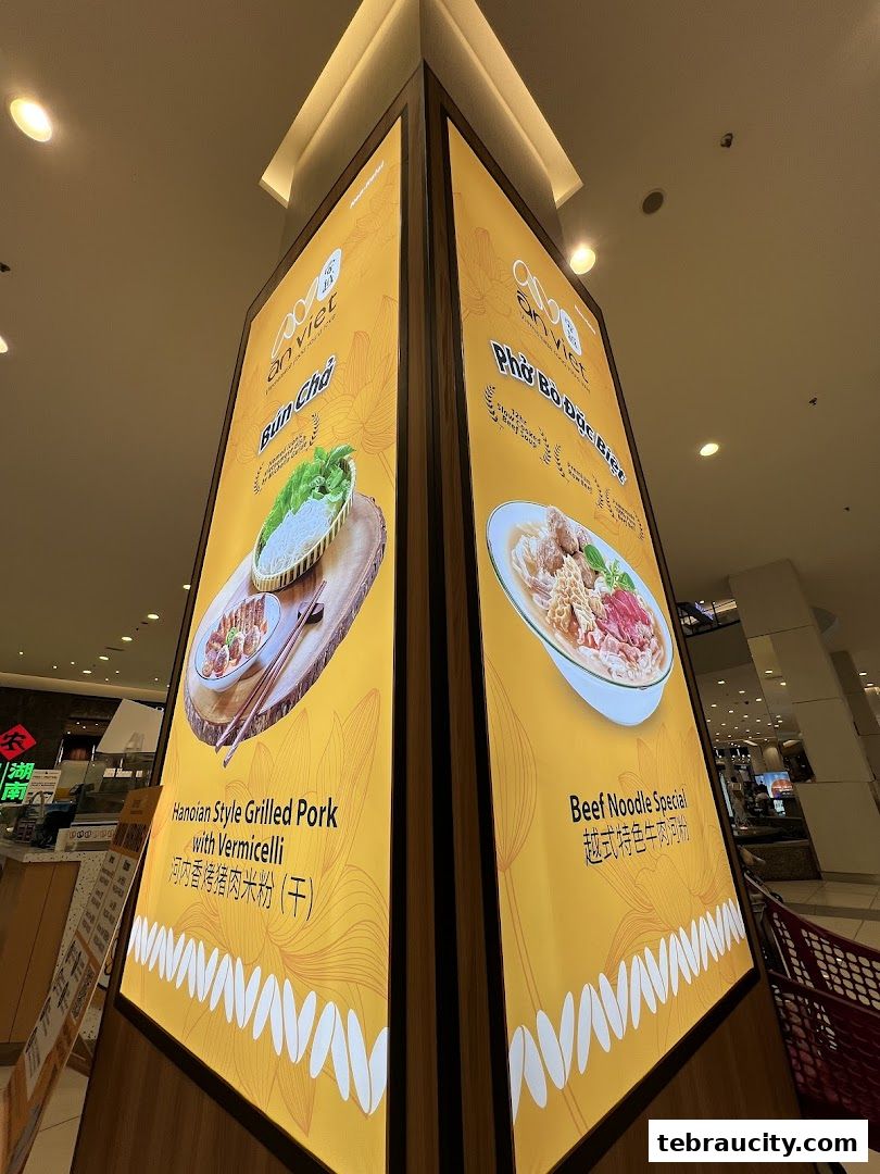 A brightly lit display showcasing Vietnamese dishes like Bun Cha and Pho.