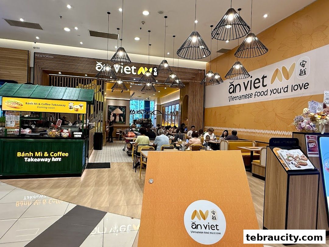 Interior of a Vietnamese restaurant with seating, a takeaway counter, and branded decor.
