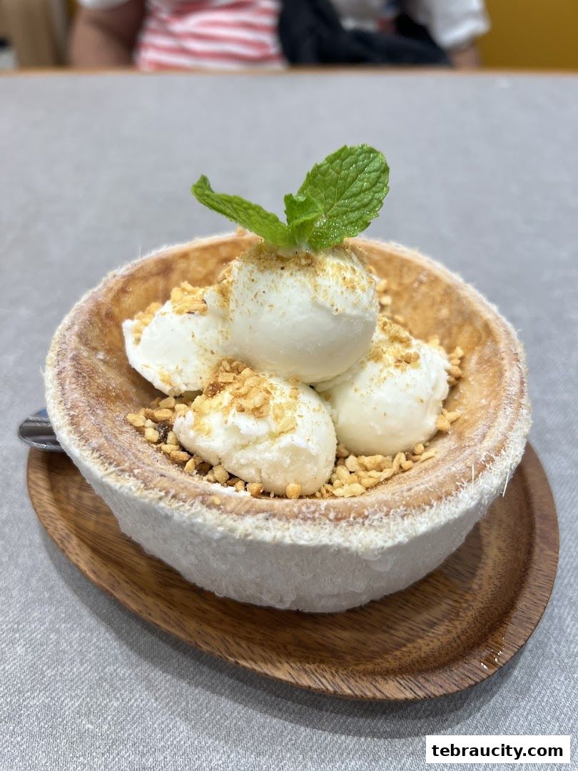 A refreshing dessert served in a coconut shell, topped with ice cream and mint.