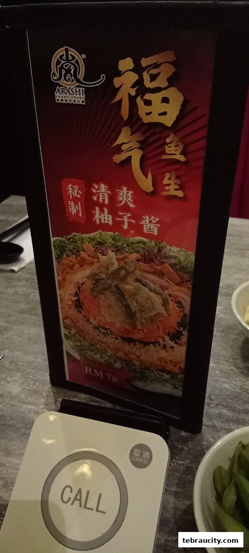 A table sign at Arashi Shabu-Shabu featuring a dish and price, with a call button.
