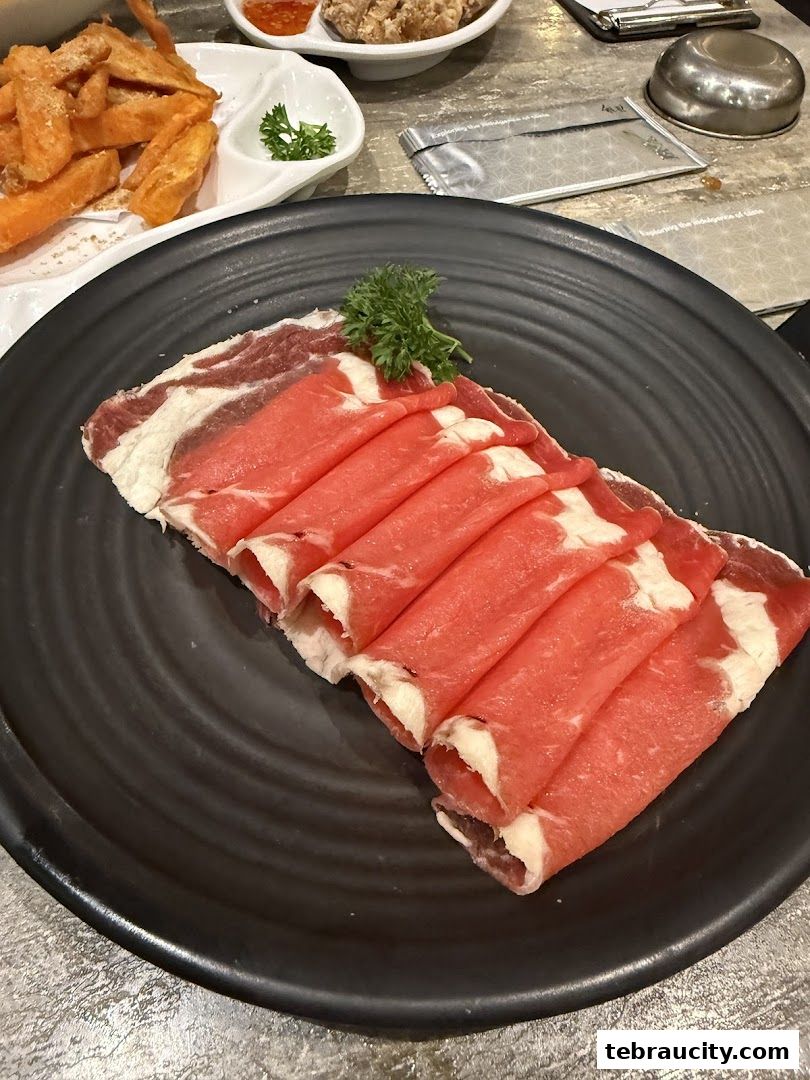 A plate of thinly sliced raw beef, garnished with parsley, ready for shabu-shabu.