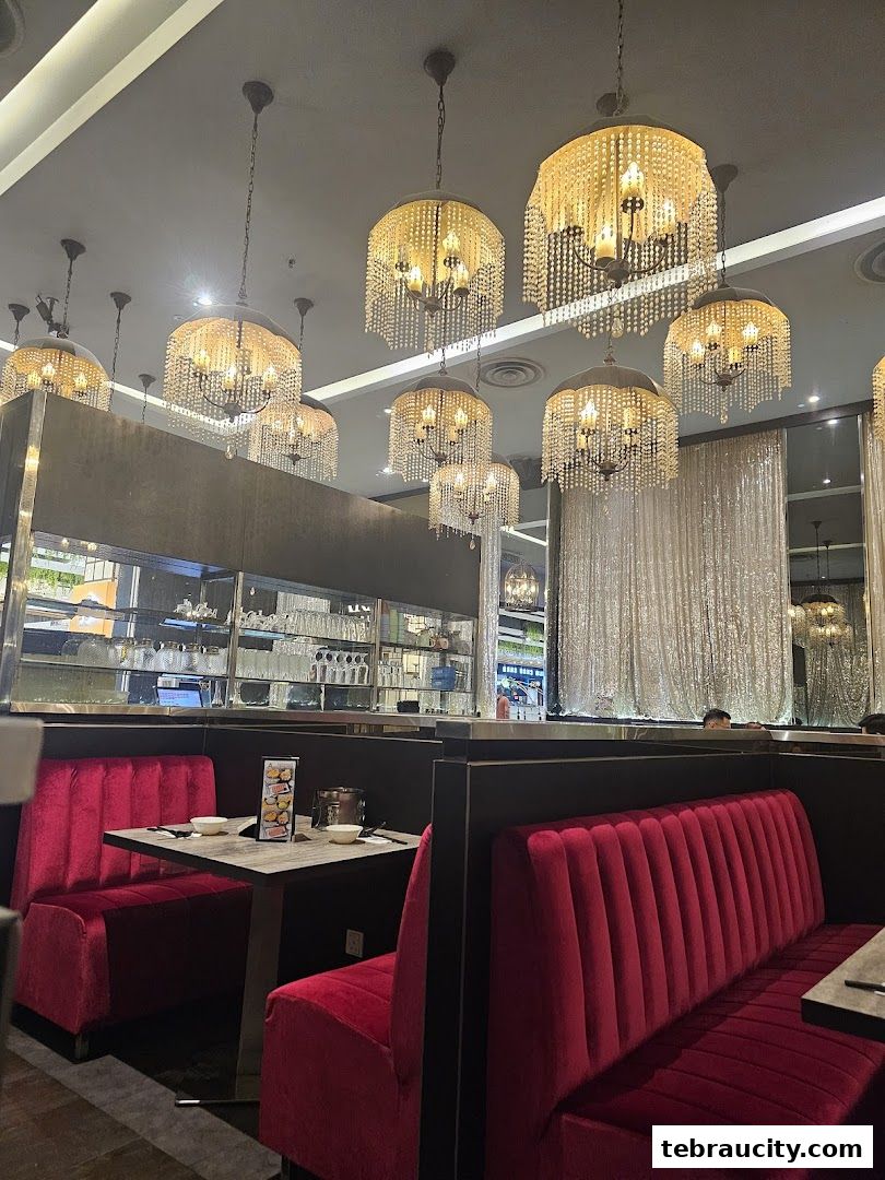 Interior of a shabu-shabu restaurant with plush red seating and ornate chandeliers.