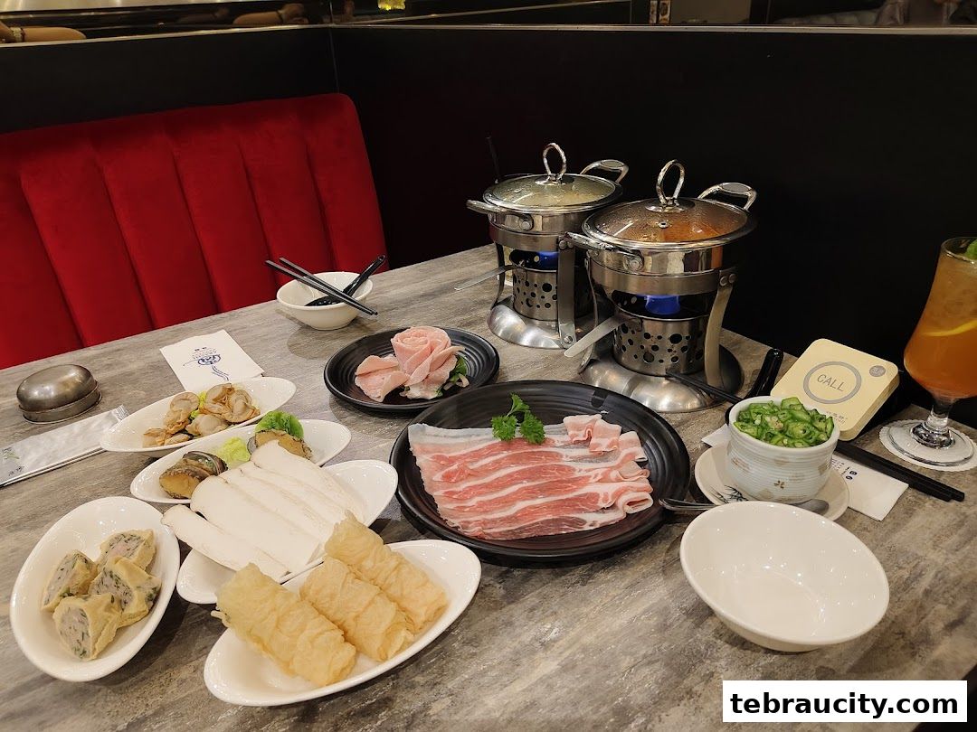 A table laden with shabu-shabu ingredients, including thinly sliced meats, seafood, and vegetables, ready for cooking.