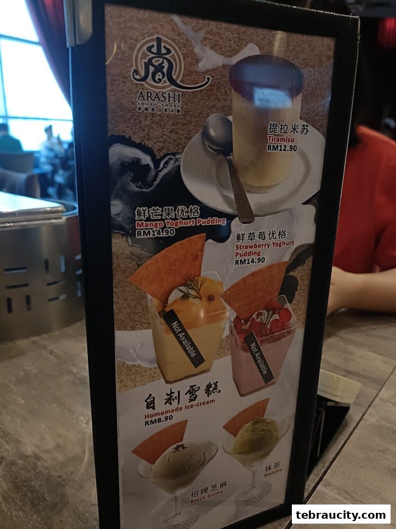 A menu board displaying desserts like Tiramisu, Mango Yoghurt Pudding, and ice cream.