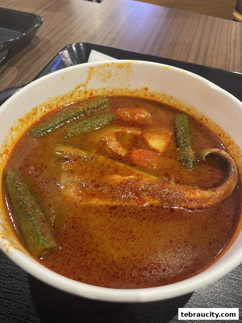 A close-up shot of a delicious bowl of Asam Pedas fish with okra.