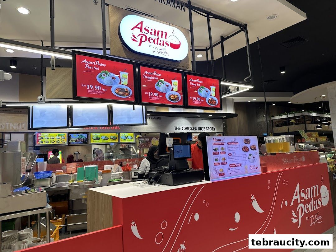A food stall with digital menus displaying set meals and a physical menu on the counter.
