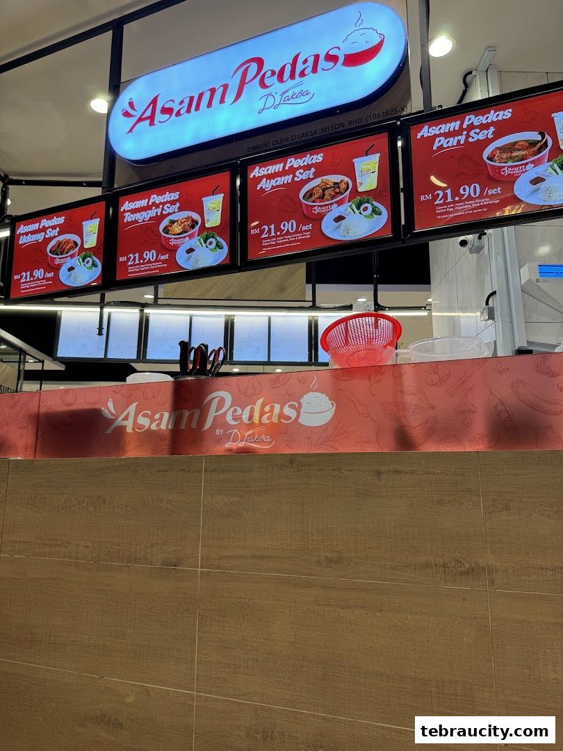 Digital menu boards displaying various Asam Pedas sets with prices.