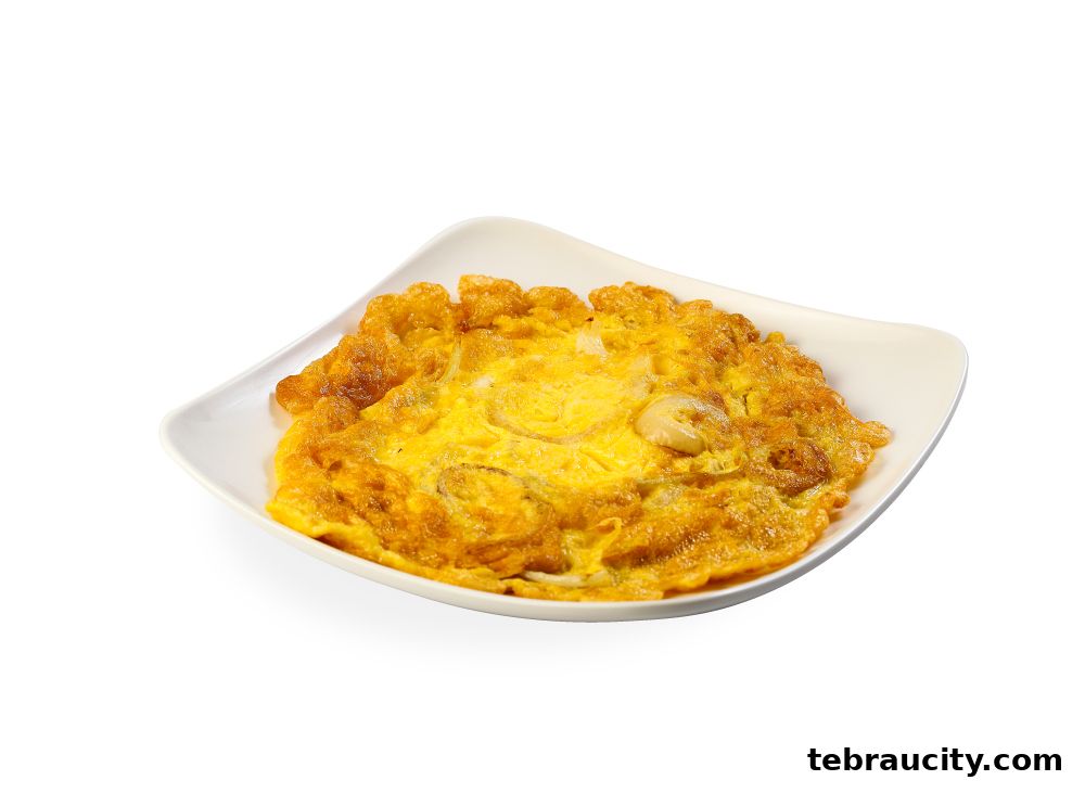 A golden-brown omelet with visible onions and a piece of shrimp on a white square plate.