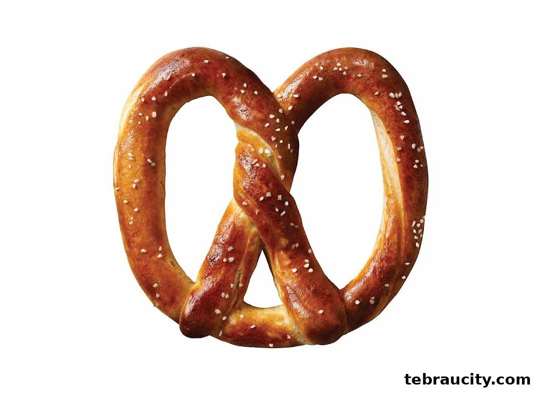 A close-up shot of a golden-brown pretzel with coarse salt sprinkled on top.