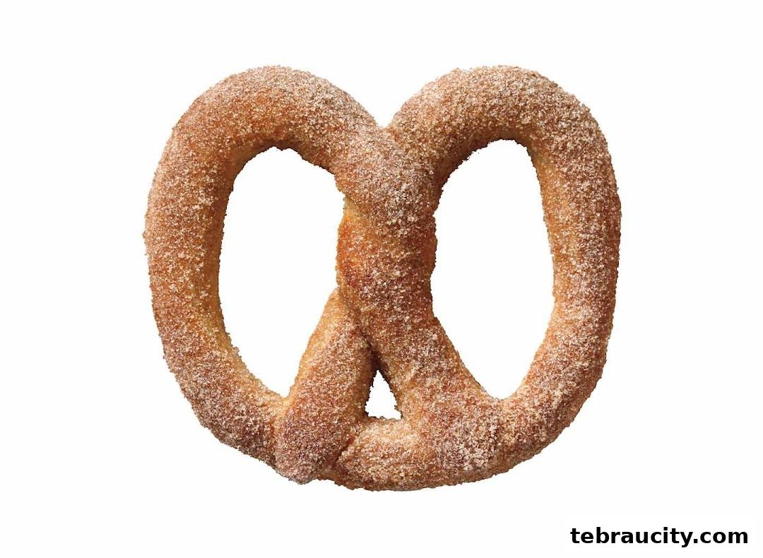 A close-up shot of a cinnamon sugar pretzel on a white background.