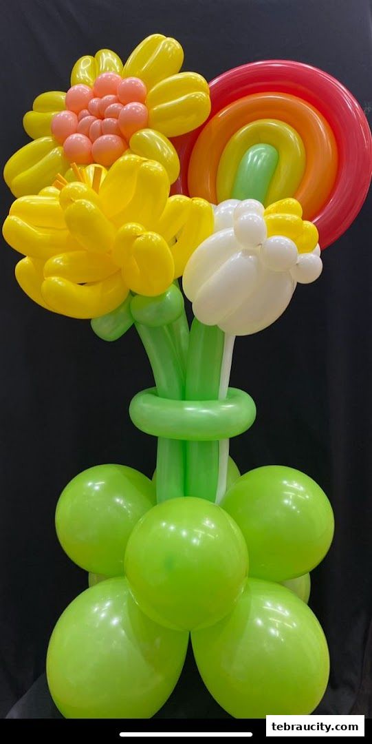 A vibrant balloon arrangement featuring flowers and a rainbow against a black background.