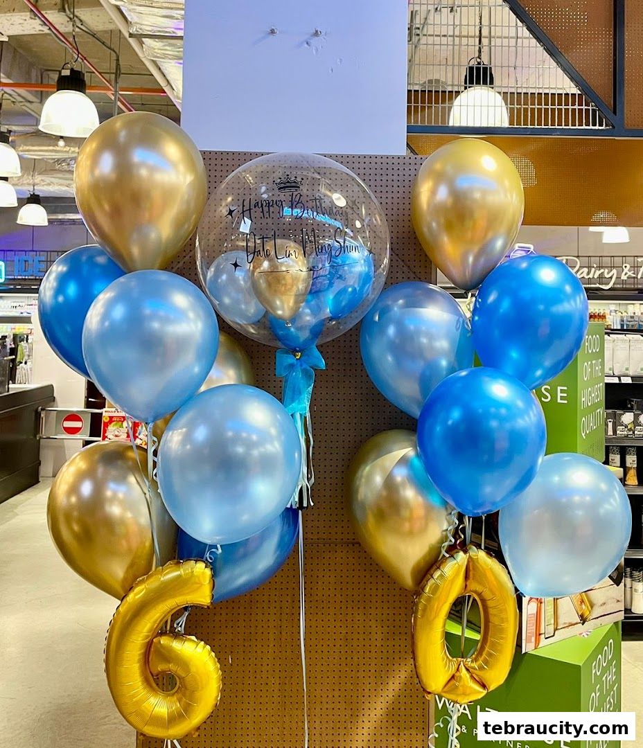 A festive display of blue and gold balloons, including a large bubble balloon with text.