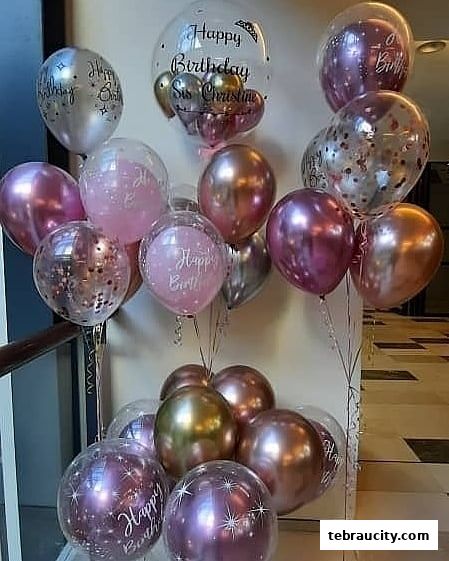 A festive display of assorted metallic and clear balloons, many with 'Happy Birthday' messages.