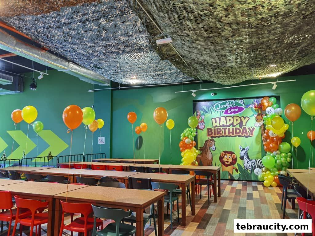 A party room decorated with balloons and a 'Happy Birthday' banner featuring jungle animals.