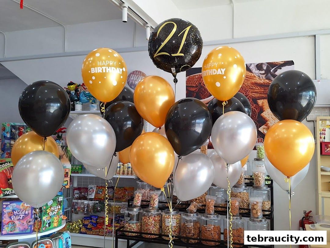 A festive display of assorted balloons, including 'Happy Birthday' and '21' themed ones, in a shop.