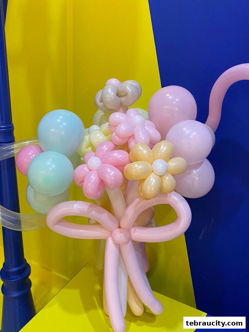 A colorful balloon bouquet shaped like flowers with a pink bow.