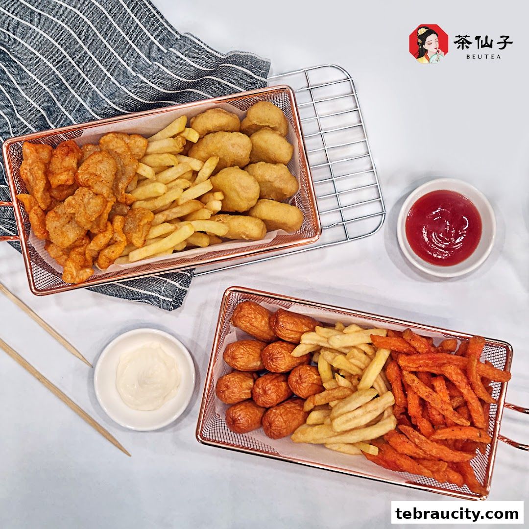Two baskets of fried snacks, including chicken nuggets, fries, sausages, and sweet potato fries, with dipping sauces.