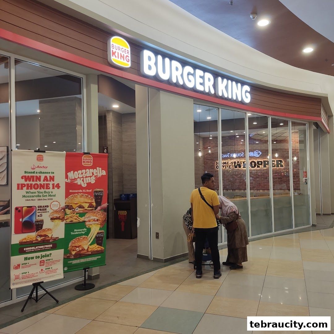 Burger King storefront with promotional banners and customers inside.