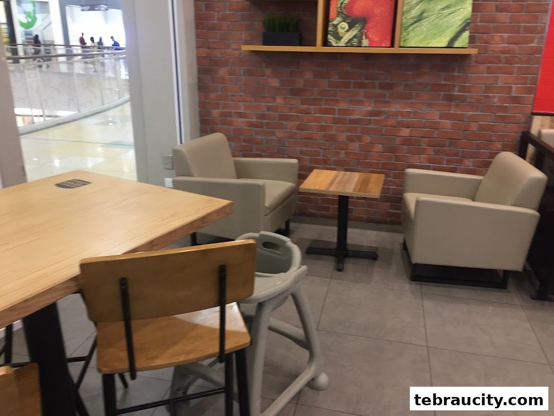 Interior seating area with tables, chairs, and a brick wall.