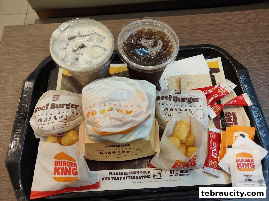 A Burger King meal on a tray with two burgers, drinks, and sides.