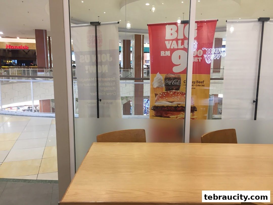 Burger King promotional banners displayed inside a shopping mall, featuring a burger meal deal.