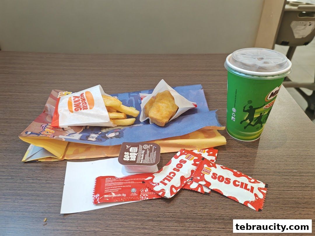 A Burger King meal featuring fries, chicken nuggets, dipping sauce, and a Milo drink.