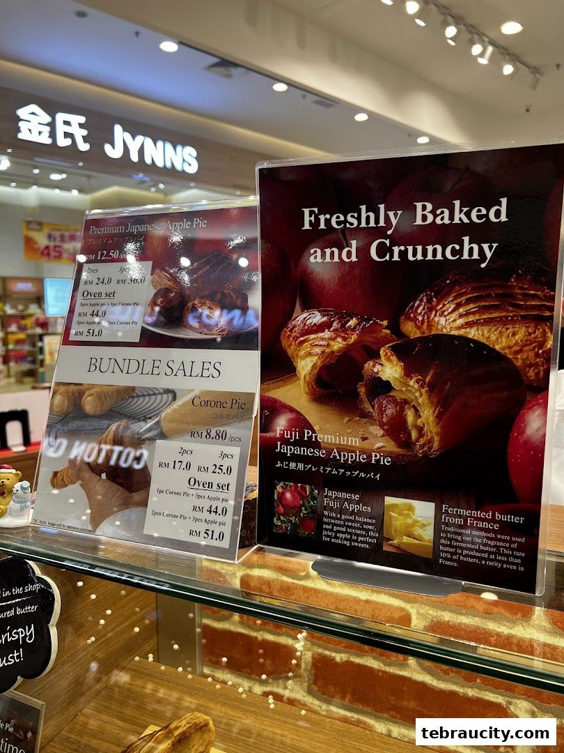 A display of freshly baked apple pies and corone pies with pricing and product details.